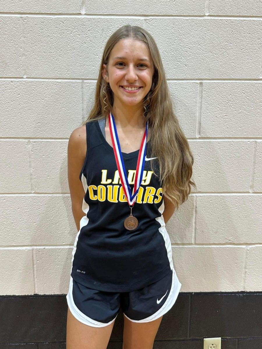 Salem Coker poses with her metal from the district cross country meet. She will be running int eh regional tournament at the end of the month. 